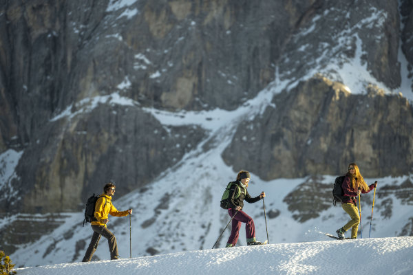 Drei Skitourengeher mit hochwertigen Skiern vor steiler Felswand – Premium Ski für sportliche Alpin-Touren